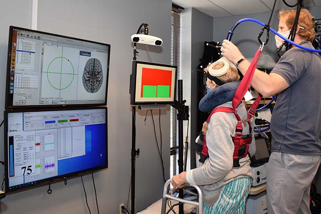 Stroke rehab study participant recieves transcranial magnetic brain stimulation from research therapist