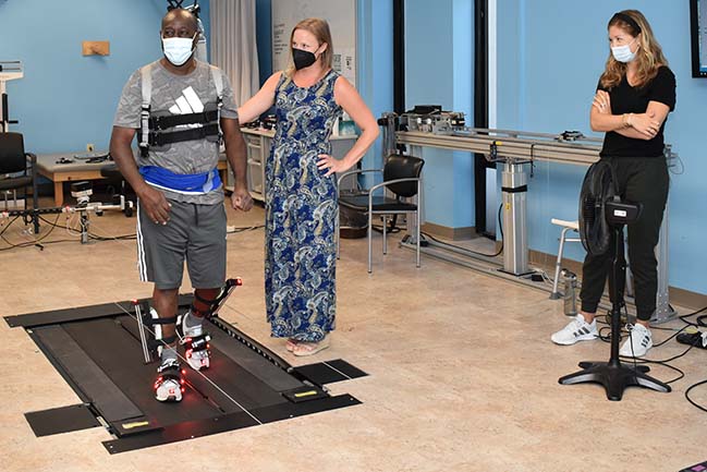 Study participant walk on treadmill, supervised by two researchers