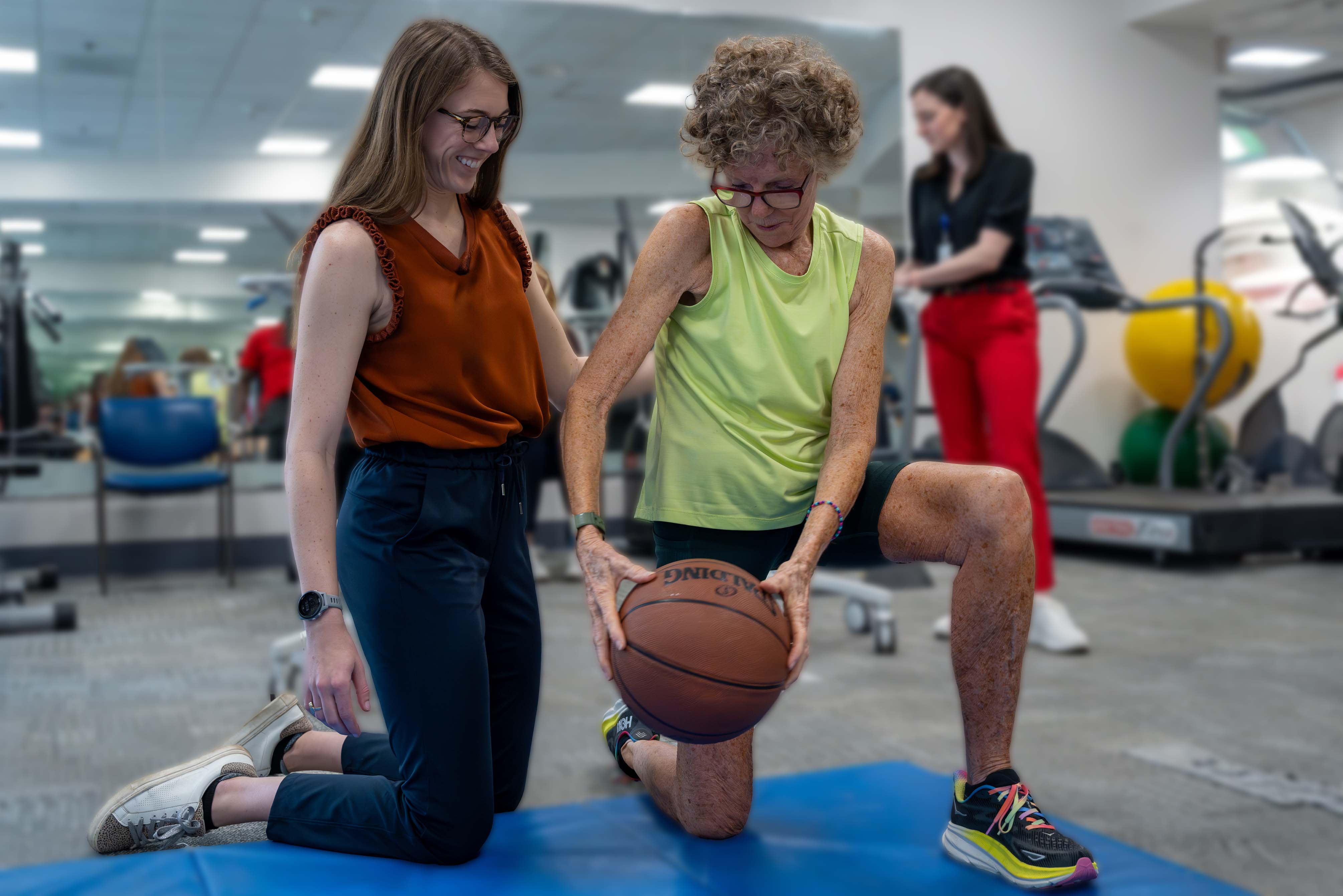 Physical therapist and patient working in a clinic with fitness equipment