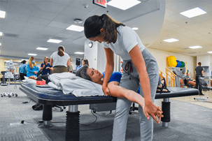 Physical therapy student works with patient.
