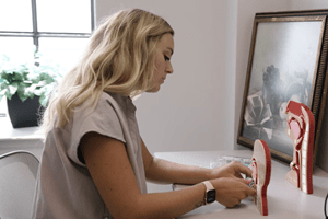 woman wearing scrubs studies a model of the human head