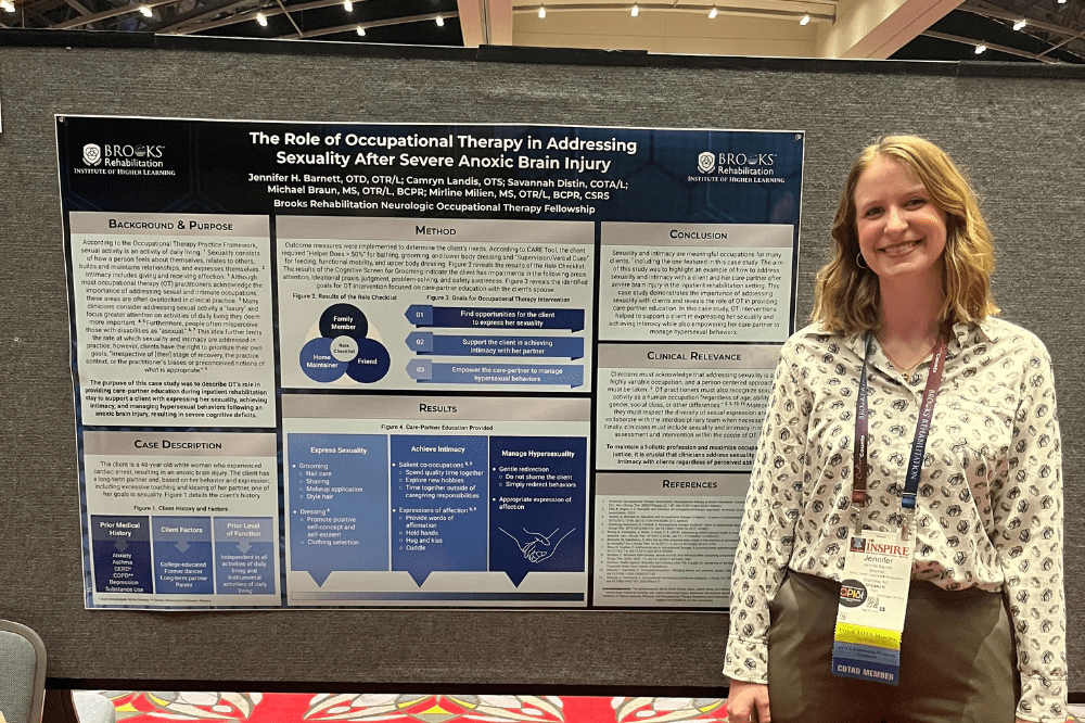 Jennifer Barnett stands in front of her research poster at the AOTA Inspire conference.
