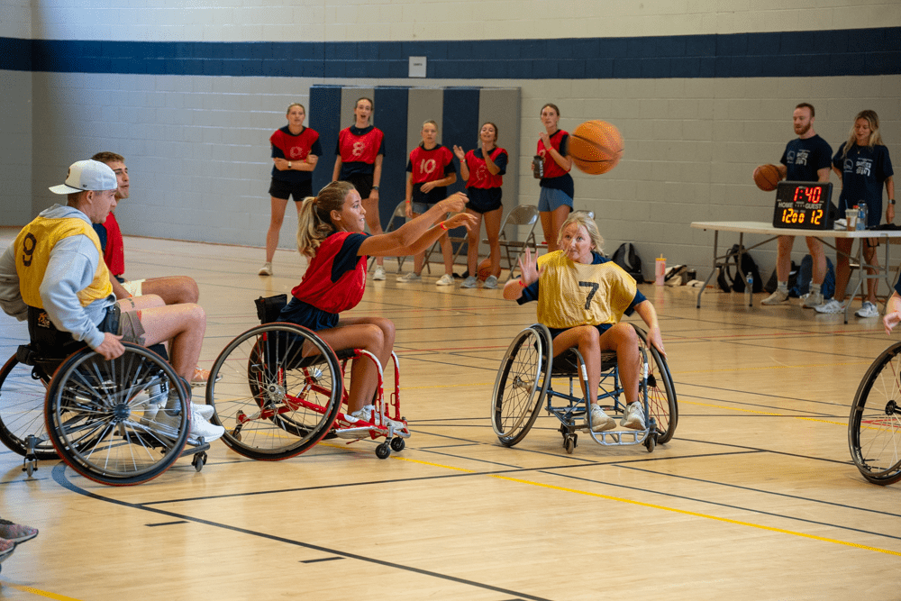 woman passes the ball in a wheelchair basketball game