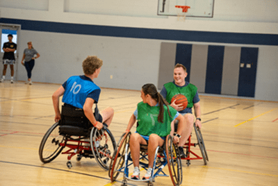 3 players go for the ball in wheelchair basketball game