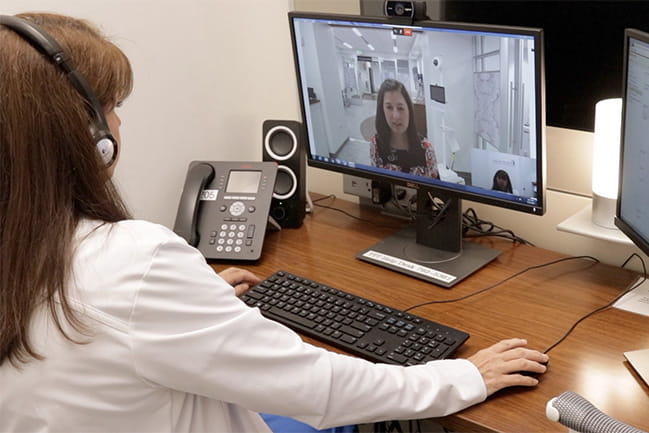 Woman practicing telehealth with a patient.