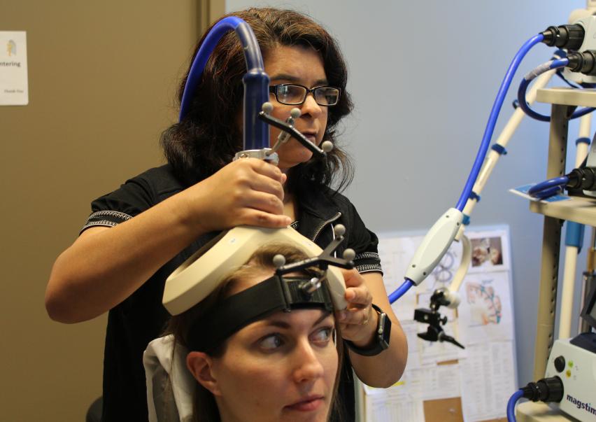 Two members of NC NM4R demonstrating the technique of Transcranial Magnetic Stimulation demonstration