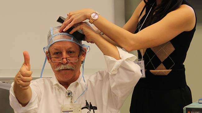 Mark George and workshop attendee demonstrate finding resting motor threshhold using transcranial magnetic stimulation coil