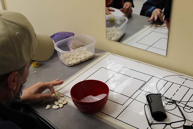 Participant move dried beans into bowl during motor skill testing 